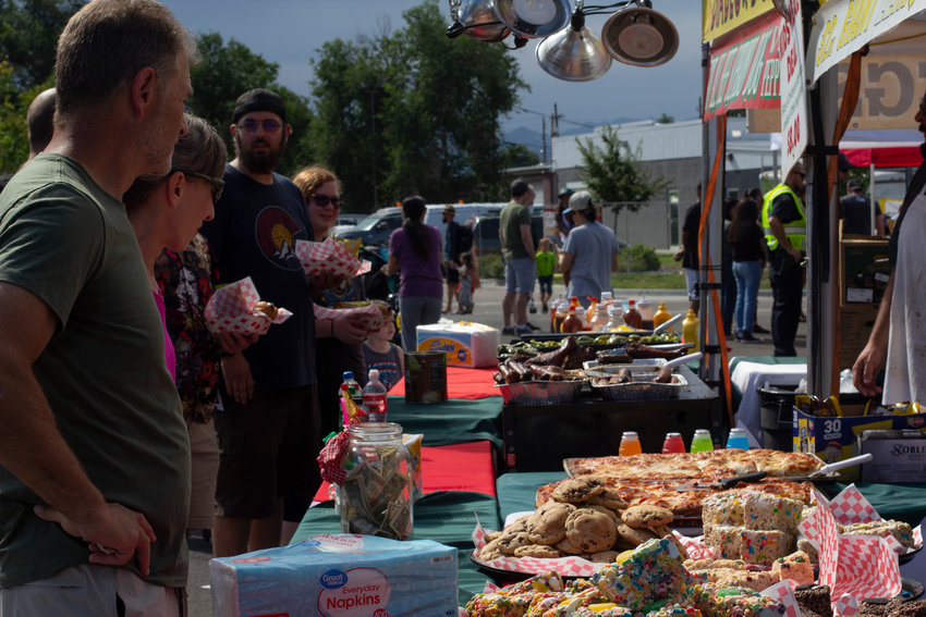A hungry Carnation Festival crowd eyes sweet treats and savory slices at the Grammy's Goodies food stand.